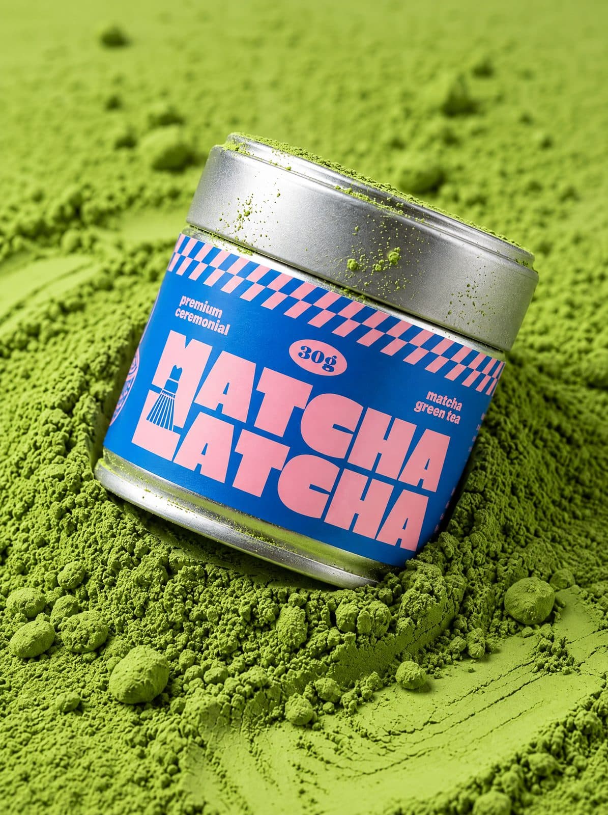 Puszka Matcha Latcha zanurzona w kopcu intensywnie zielonego proszku matcha